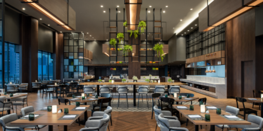 Interior view of the Avani Sukhumvit Bangkok Hotel restaurant, showcasing stylish seating and ambient lighting for guests.